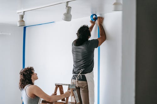 couple conducting maintenance tasks on their house